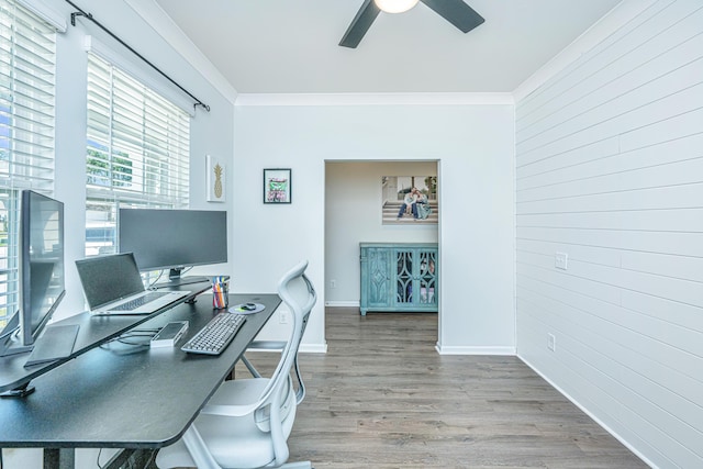 office featuring crown molding, wood finished floors, baseboards, ceiling fan, and wooden walls