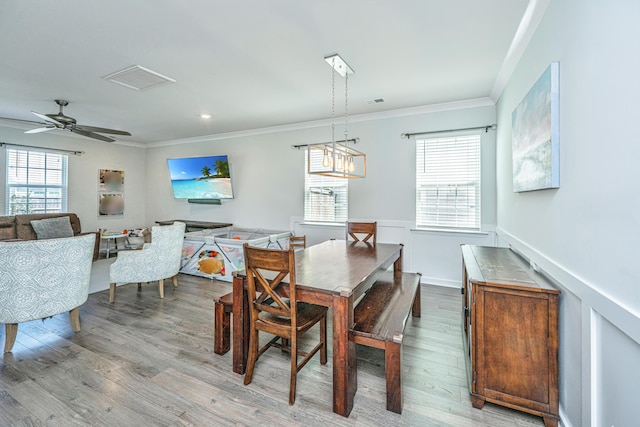 dining room with crown molding, plenty of natural light, and wood finished floors
