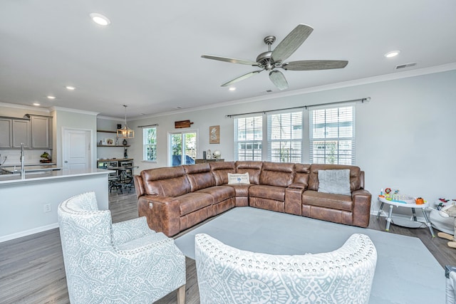 living room with crown molding, light wood finished floors, recessed lighting, a ceiling fan, and visible vents
