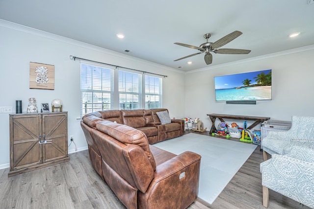 living area with crown molding, ceiling fan, wood finished floors, and visible vents