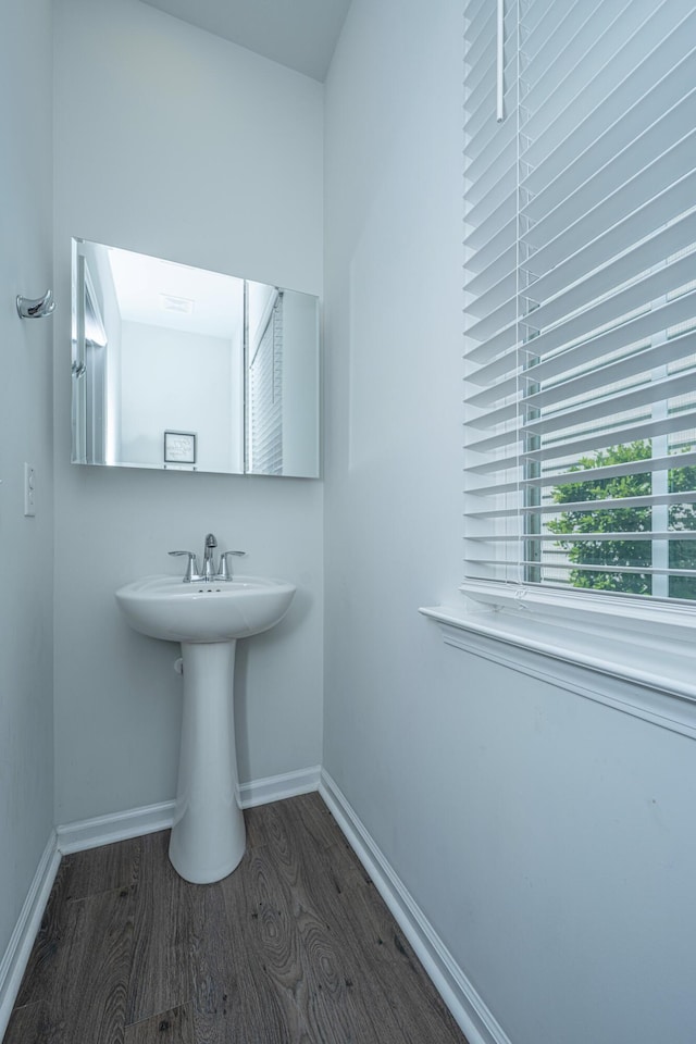 bathroom featuring a sink, baseboards, and wood finished floors