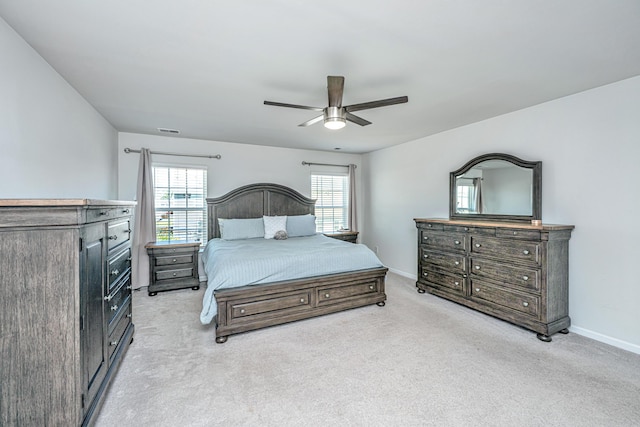 bedroom with a ceiling fan, baseboards, and light colored carpet