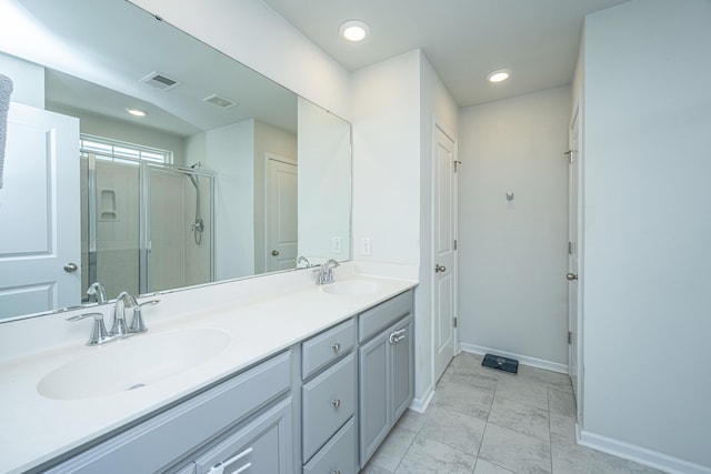 full bathroom featuring visible vents, a sink, double vanity, and a shower stall