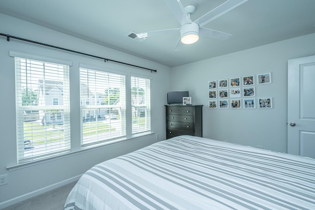 carpeted bedroom featuring baseboards, ceiling fan, and visible vents