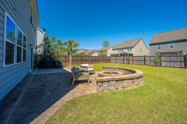 view of yard featuring a fenced backyard, a patio area, a residential view, and an outdoor fire pit