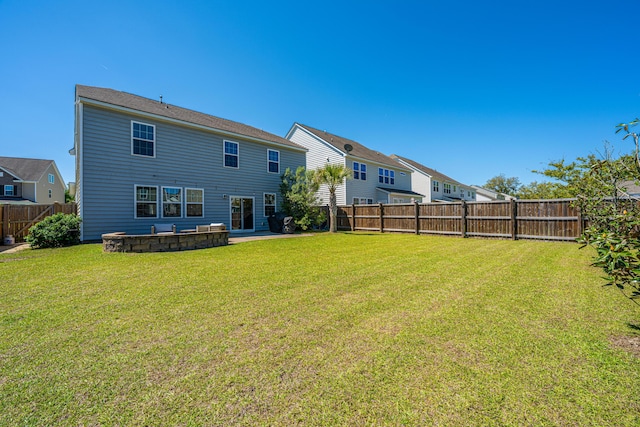 rear view of property featuring a lawn and a fenced backyard