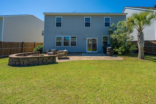 back of house featuring a fenced backyard, a patio, a yard, and a fire pit