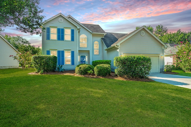 view of front of property with a garage and a lawn