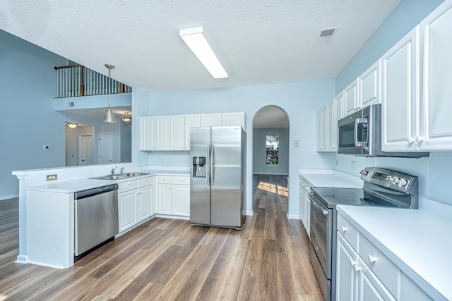 kitchen with sink, white cabinetry, hanging light fixtures, kitchen peninsula, and stainless steel appliances