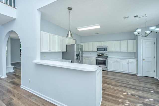 kitchen featuring stainless steel appliances, kitchen peninsula, and white cabinets