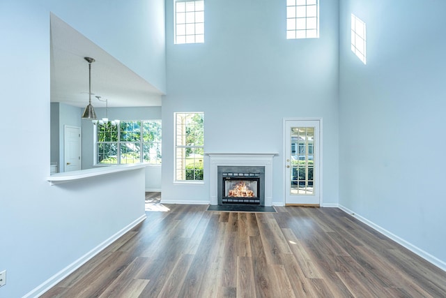 unfurnished living room with a high ceiling and dark hardwood / wood-style flooring