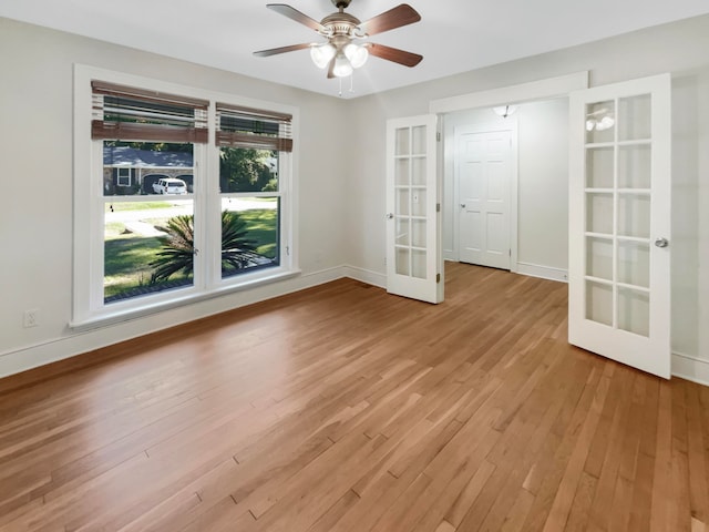 unfurnished room featuring french doors, light wood-type flooring, and ceiling fan