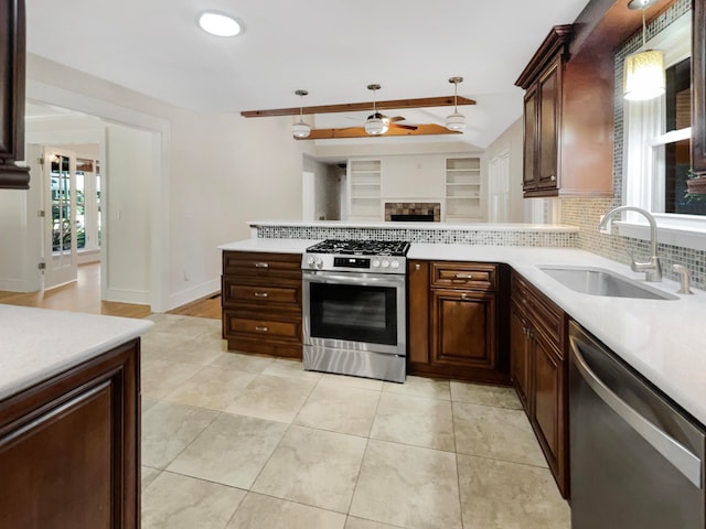 kitchen with appliances with stainless steel finishes, sink, ceiling fan, decorative light fixtures, and decorative backsplash