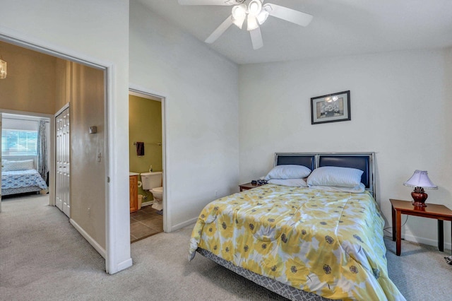 bedroom featuring ceiling fan, lofted ceiling, ensuite bath, and light carpet