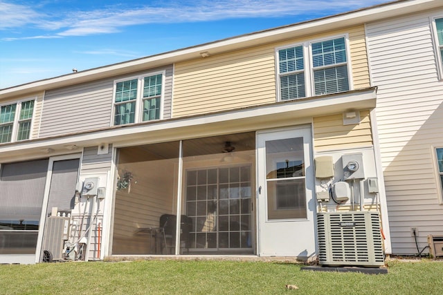 back of house featuring a yard and a sunroom