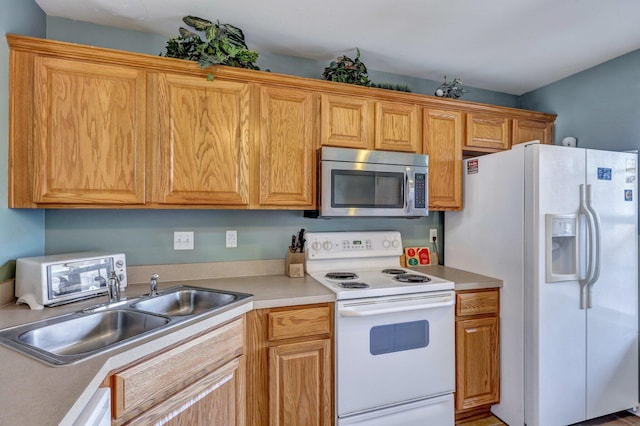 kitchen featuring white appliances and sink