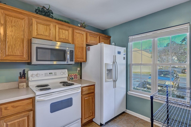 kitchen featuring white appliances and light tile patterned flooring