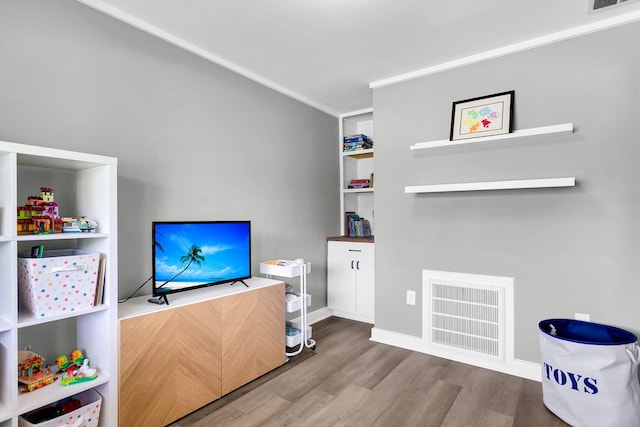 interior space with built in features, crown molding, and hardwood / wood-style flooring