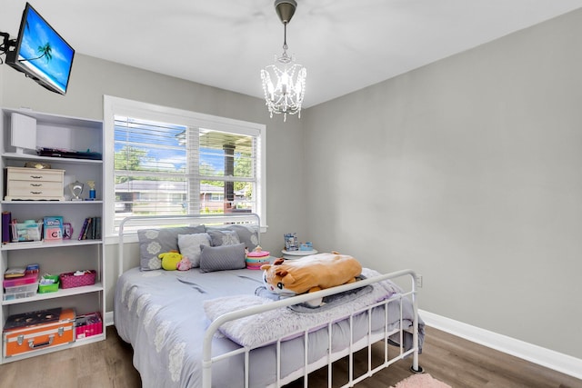 bedroom with a chandelier and hardwood / wood-style floors