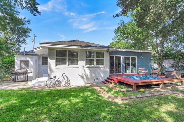 rear view of house with a yard and a wooden deck