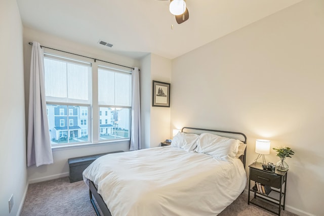 carpeted bedroom featuring ceiling fan and multiple windows