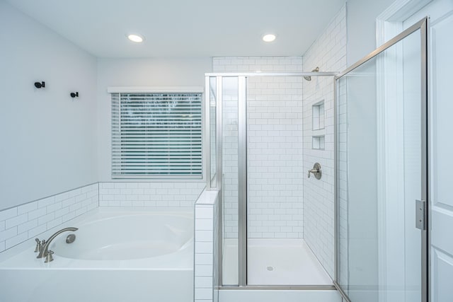 bathroom featuring separate shower and tub