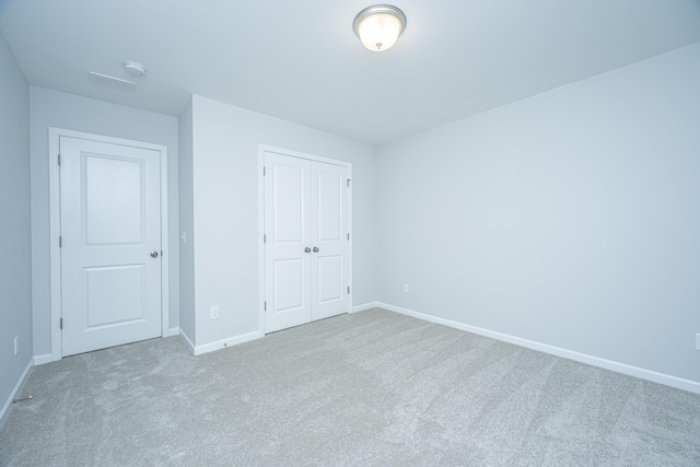 unfurnished bedroom featuring carpet flooring and a closet