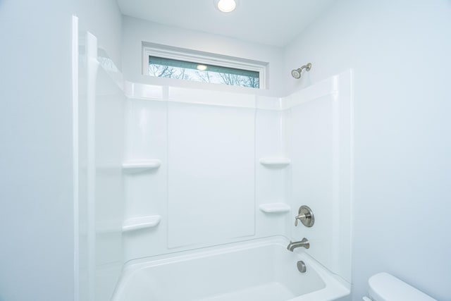 bathroom featuring tub / shower combination and toilet