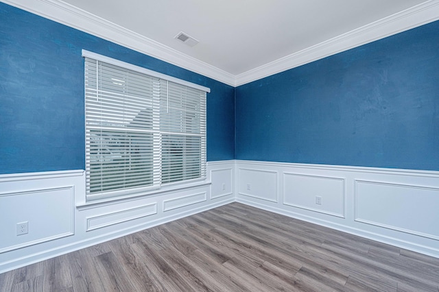 empty room with hardwood / wood-style floors and crown molding