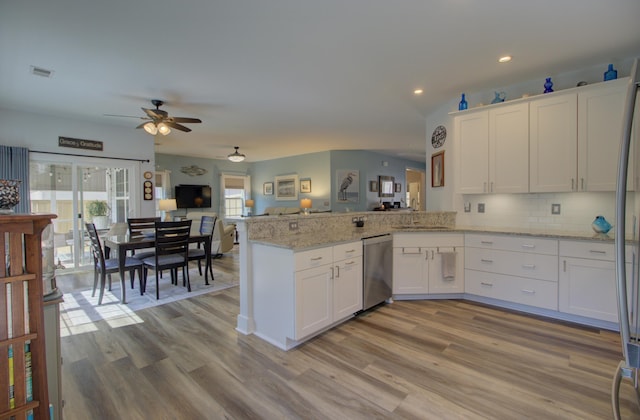 kitchen featuring stainless steel dishwasher, a peninsula, white cabinets, and visible vents