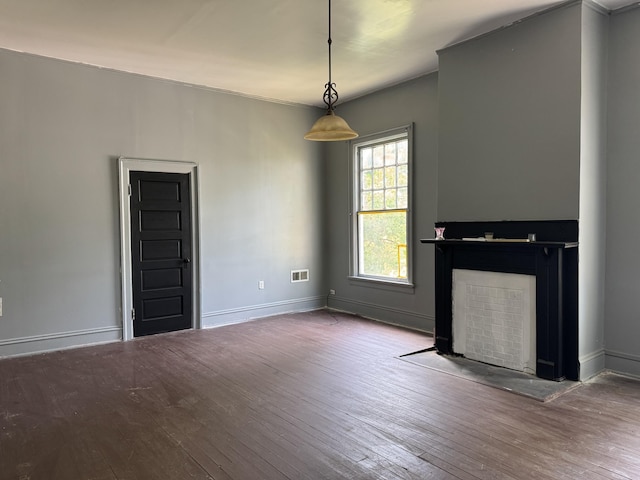 unfurnished living room with a fireplace with flush hearth, hardwood / wood-style flooring, baseboards, and visible vents