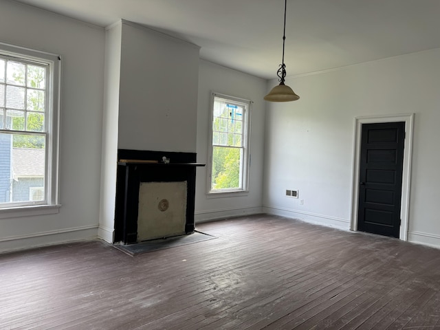 unfurnished living room with baseboards, crown molding, and hardwood / wood-style floors