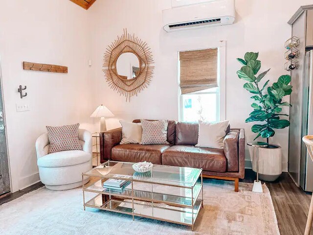 living room featuring wood-type flooring and a wall unit AC