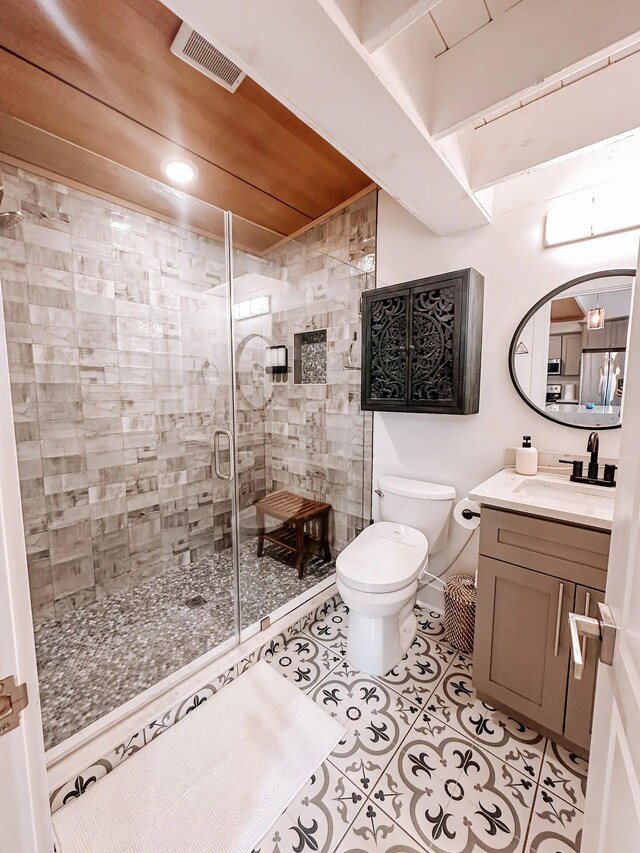 bathroom featuring toilet, tile patterned flooring, an enclosed shower, and vanity