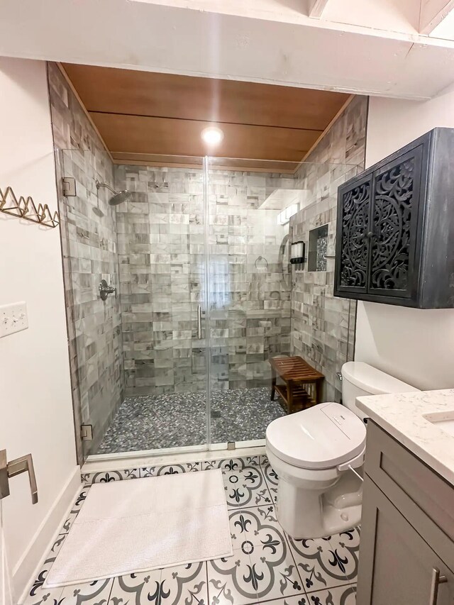 bathroom with a shower with shower door, tile patterned floors, vanity, and toilet