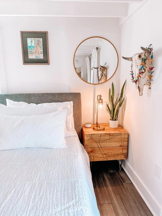 bedroom featuring dark hardwood / wood-style floors and beam ceiling