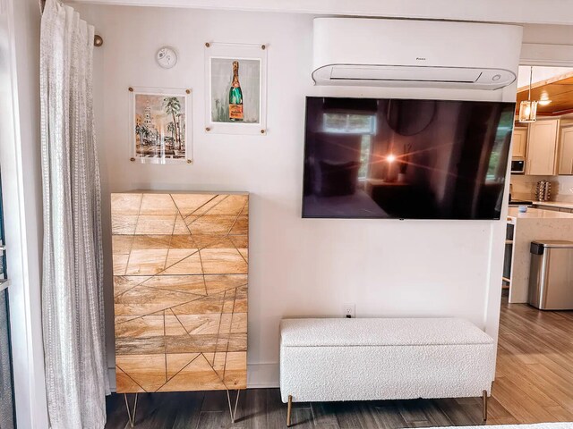 living area with dark wood-type flooring and a wall unit AC