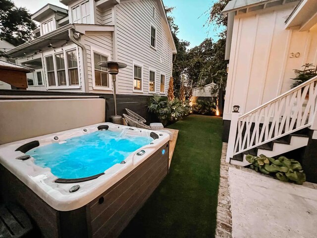 exterior space with a hot tub and a yard