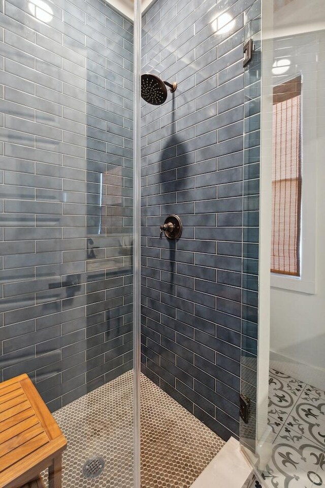 bathroom with tile patterned floors and a shower with shower door