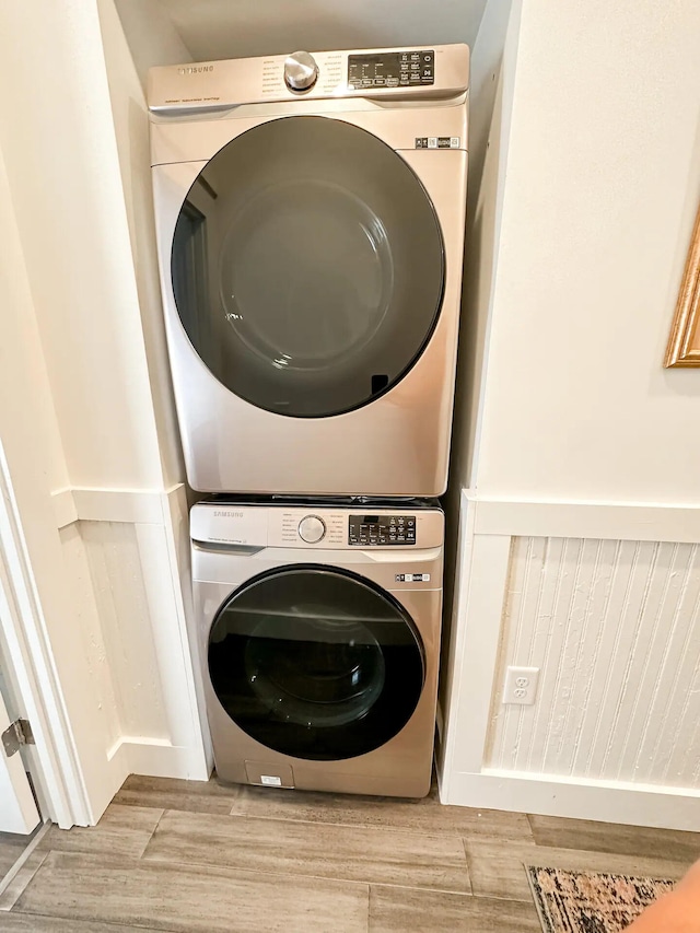 clothes washing area featuring stacked washing maching and dryer