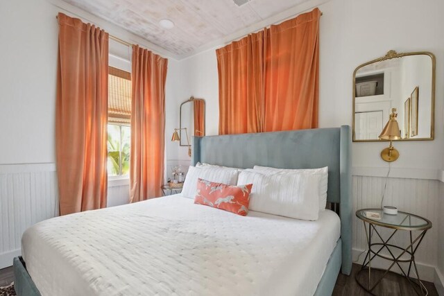 bedroom featuring radiator heating unit and hardwood / wood-style flooring