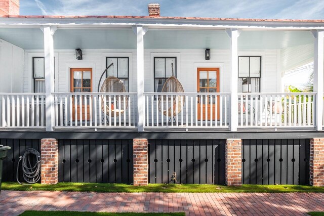 back of property featuring covered porch