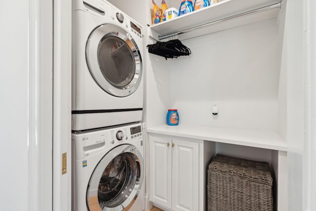 washroom featuring cabinets and stacked washer / drying machine