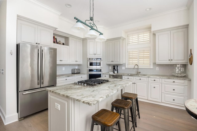 kitchen featuring hardwood / wood-style floors, a kitchen island, stainless steel appliances, and sink