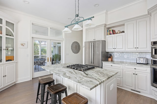 kitchen featuring light wood-type flooring, a center island, stainless steel appliances, and white cabinets