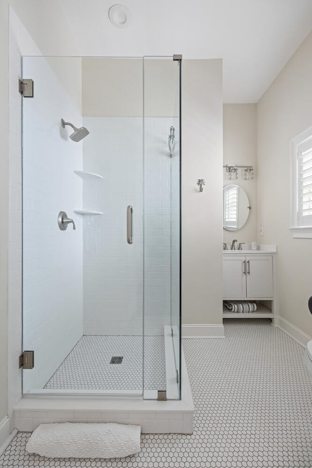 bathroom with vanity, walk in shower, and tile patterned flooring