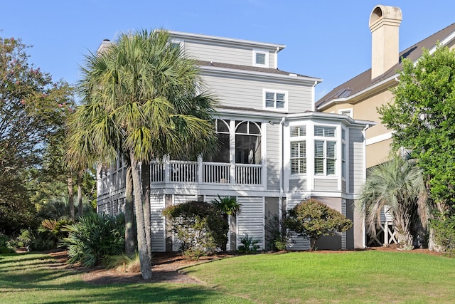 back of house featuring a sunroom and a yard