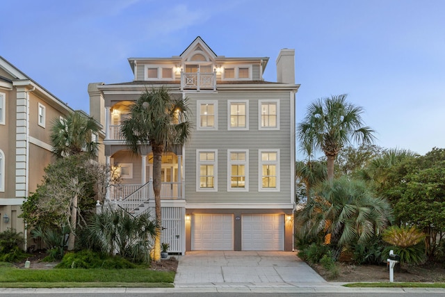 raised beach house featuring a garage and a balcony