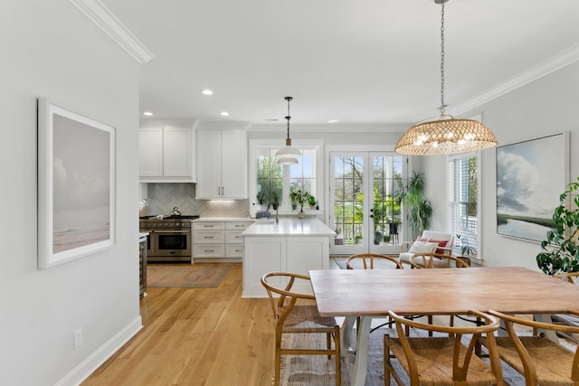 dining room with crown molding, light wood-style floors, french doors, and recessed lighting
