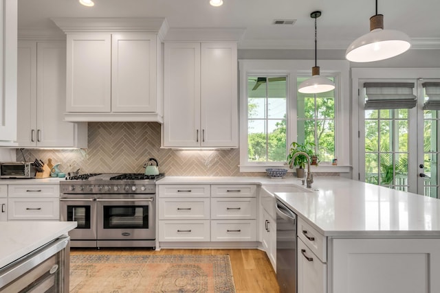 kitchen featuring visible vents, light countertops, white cabinetry, a sink, and appliances with stainless steel finishes